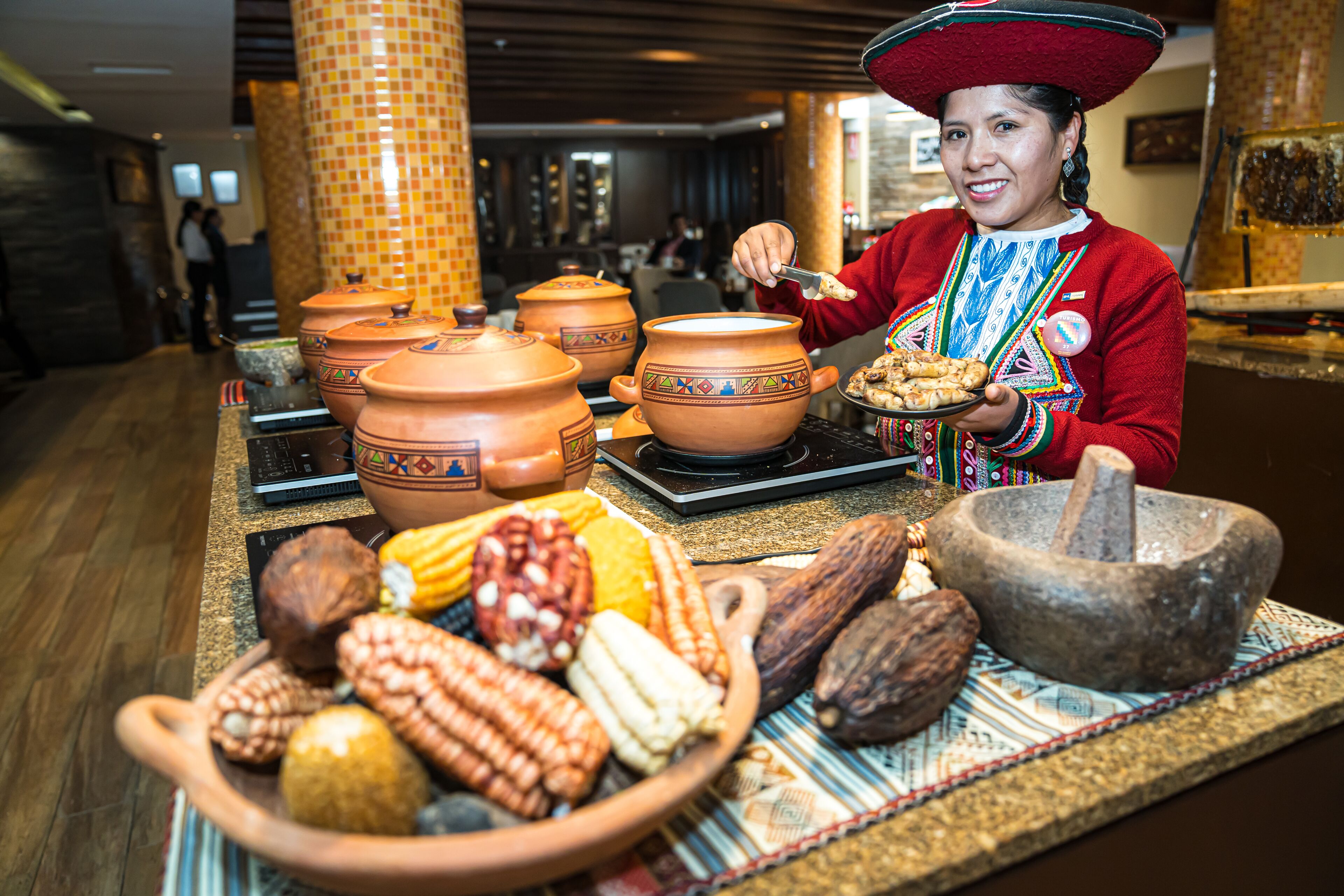 A person serving food at a counter with traditional pottery and a mortar and pestle.