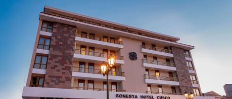 Un hotel de varios pisos con balcones, una entrada visible y un letrero que dice "SONESTA HOTEL CISCO".