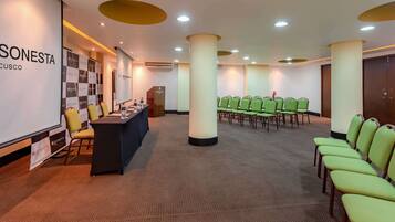 A conference room with a presentation screen, a podium, and rows of chairs.