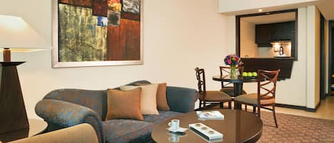 Una sala de estar con un sofá, una mesa de centro y una zona de comedor con sillas y una mesa.