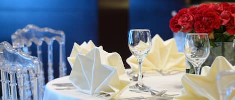 Una mesa dispuesta con servilletas blancas, cubiertos y copas de vidrio.