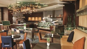 Een modern restaurantinterieur met een bar, zitgedeelte en een kok die kookt.