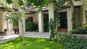A courtyard with a statue, a pergola, and a building with barred windows. - Sandton Lodge Rivonia (Sandton)