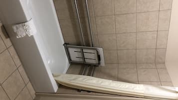 A bathroom with a shower, a toilet, and a towel rack.