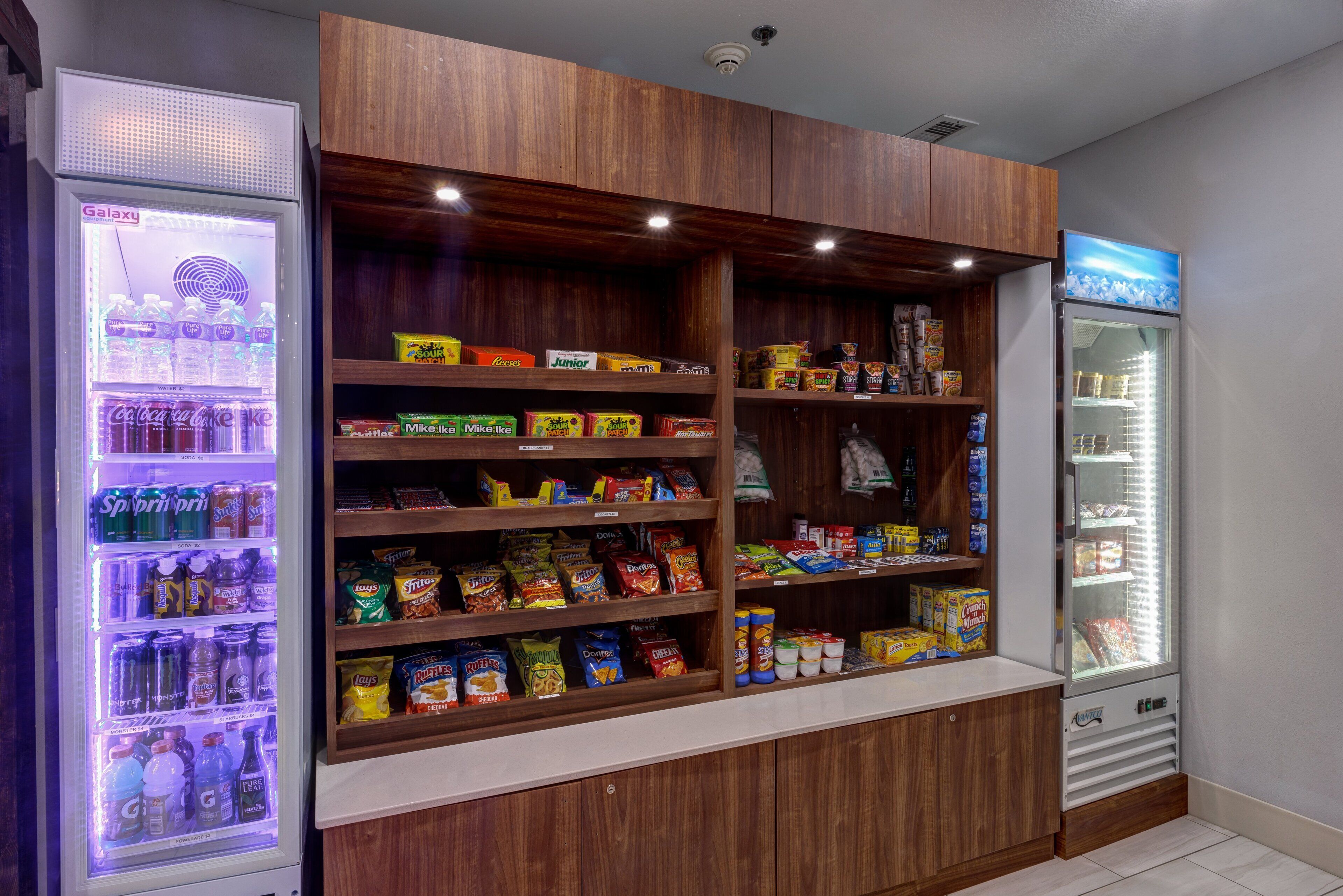 A vending area with multiple snack and drink options, including a Galaxy refrigerator and a freezer.