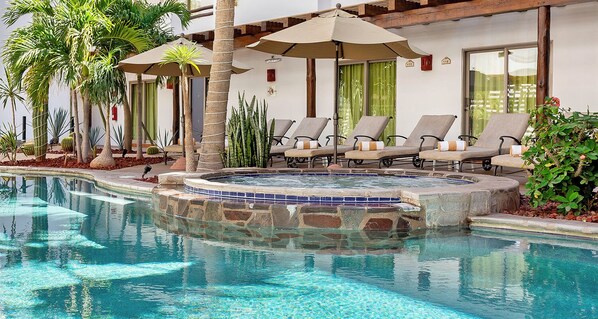 Alberca al aire libre, sombrillas en la alberca y camastros 