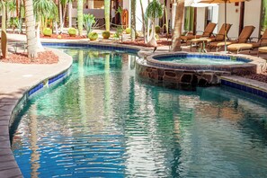 Una piscina al aire libre, sombrillas, tumbonas
