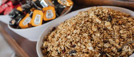 A bowl of granola with nuts and dried fruits.