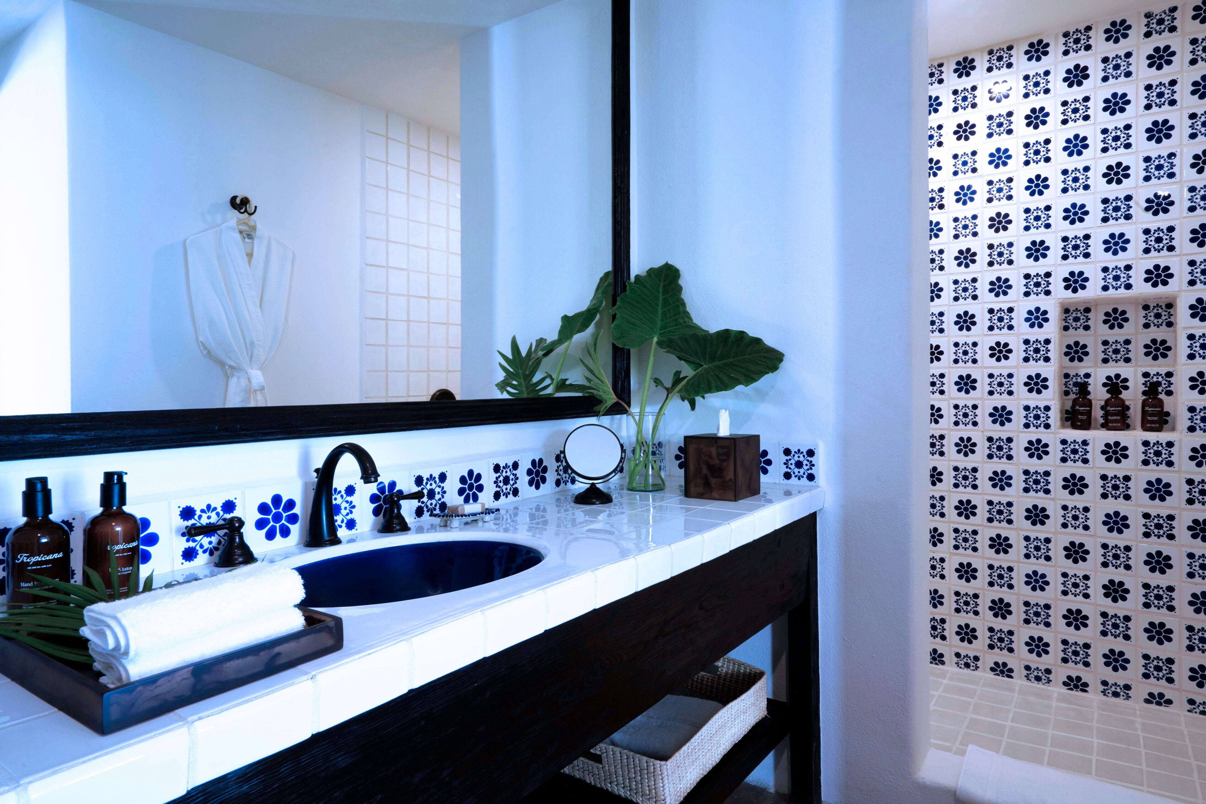 Un baño con un espejo grande, un lavabo y una zona de ducha.