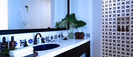 Un baño con un espejo grande, un lavabo y una zona de ducha.