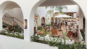 An indoor patio area with seating, a staircase, and a water feature. - Tropicana Los Cabos, Tapestry Collection by Hilton (San José del Cabo)