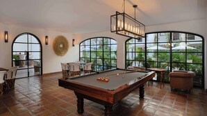 A billiards table in a room with large arched windows and a pool table. - Tropicana Los Cabos, Tapestry Collection by Hilton (San José del Cabo)