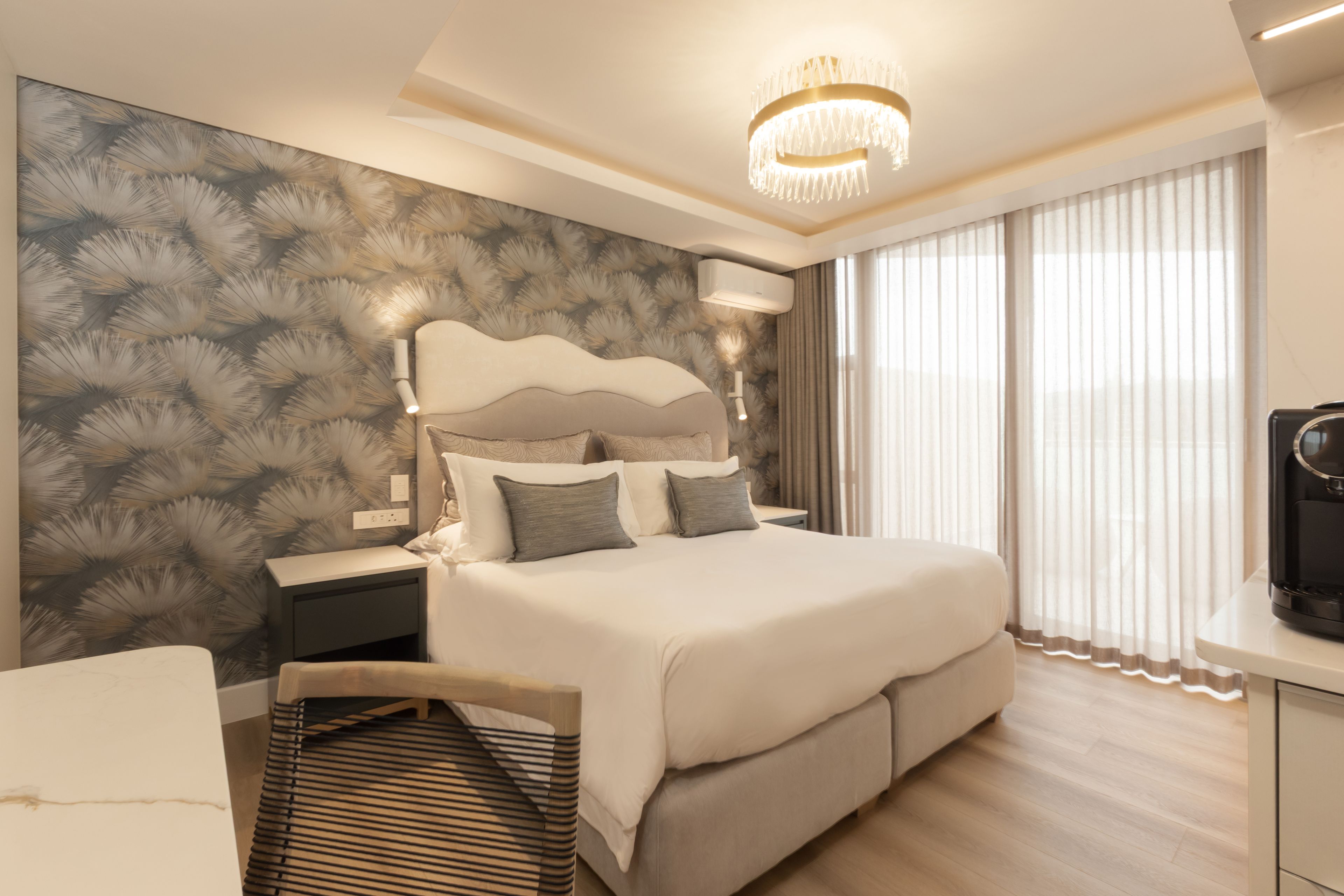 A modern bedroom with a large bed, a bedside table, a lamp, and a ceiling light.