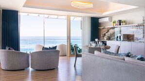 Een moderne woonkamer met uitzicht op de oceaan, een keuken met marmeren werkbladen en een kroonluchter.