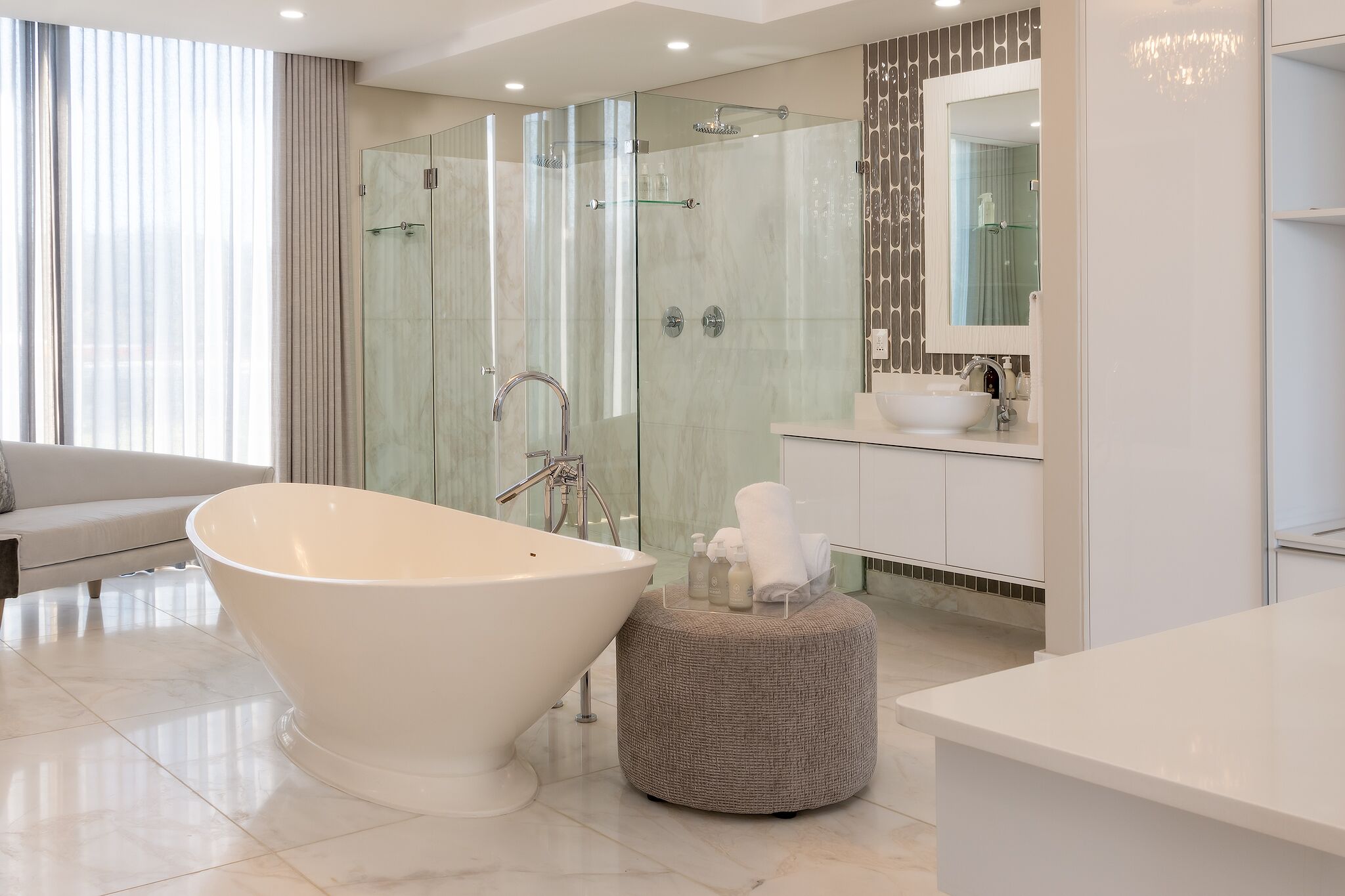 Une salle de bain moderne avec une baignoire sur pieds, une douche à parois de verre et un meuble-lavabo avec un miroir.
