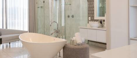 Une salle de bain moderne avec une baignoire sur pieds, une douche à parois de verre et un meuble-lavabo avec un miroir.