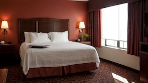 A hotel room with a large bed, two bedside lamps, a TV, and a window with curtains. - Hampton Inn & Suites Aberdeen (Aberdeen)