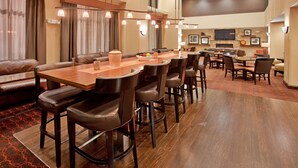 A spacious conference room with a long wooden table, multiple chairs, and a television screen. - Hampton Inn & Suites Aberdeen (Aberdeen)