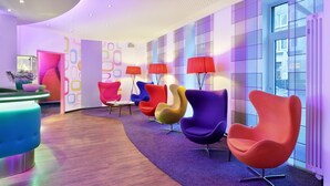 A modern lounge area with colorful chairs and a reception desk. - Cityhotel Thüringer Hof new CLASSIC (Hannover)