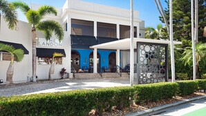 Un edificio moderno con un letrero que dice "The Landon". Cuenta con una zona de estar al aire libre cubierta, con sillas y una pared decorativa.
