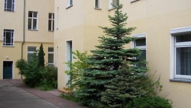 A residential building with a small evergreen tree in the foreground. - Hotel Pension Streuhof Berlin (Berlin)