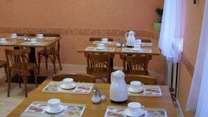 A dining area with tables set for breakfast, including cups, saucers, and a pitcher. - Hotel Pension Streuhof Berlin (Berlin)