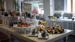 A buffet table with various food items, including pastries, desserts, and beverages. - Hotel Kastel (Motovun)