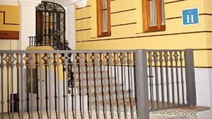 Entrada de un hotel con el nombre 'ALMONA' en el cartel sobre la puerta.