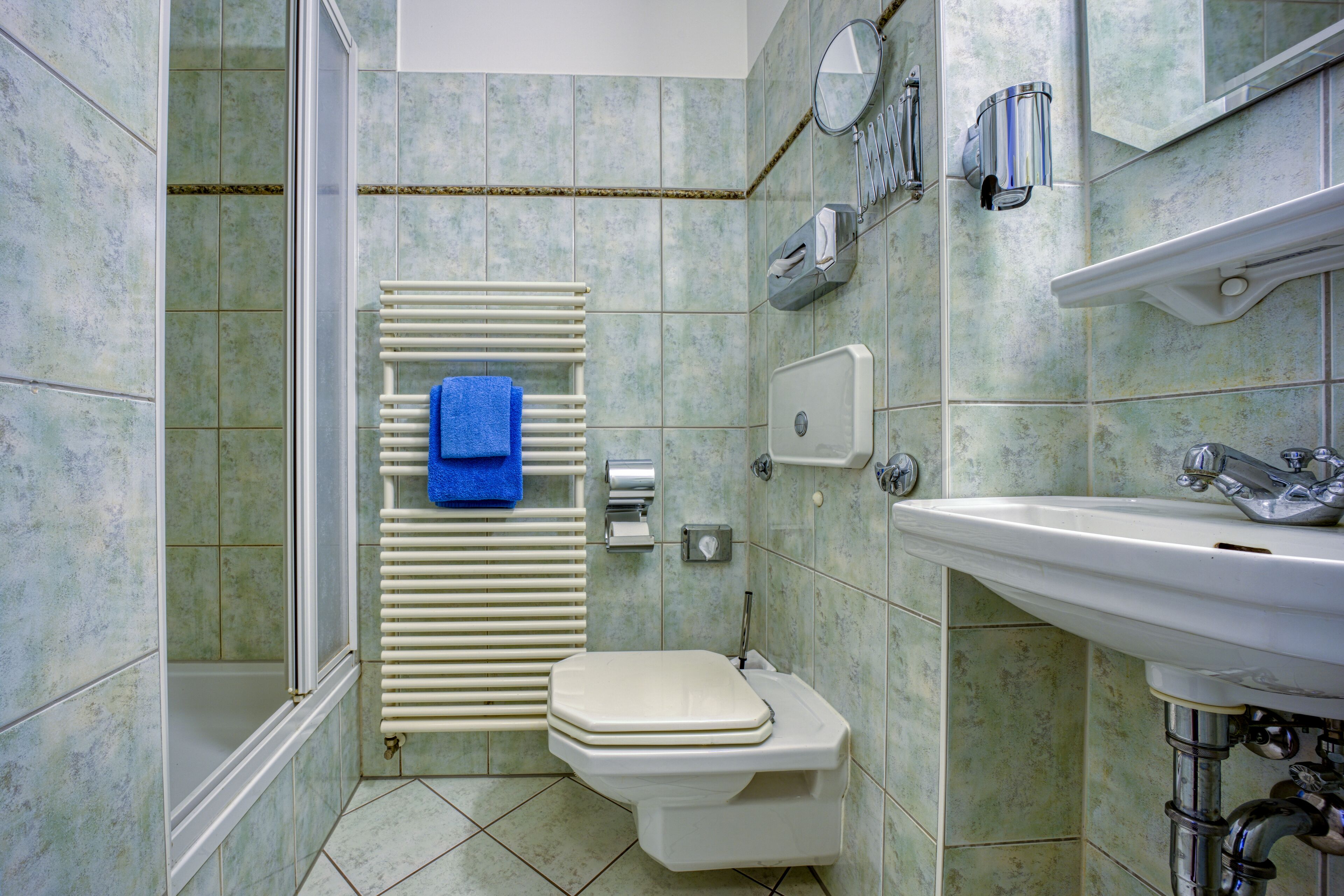 A bathroom with a toilet, sink, and shower.