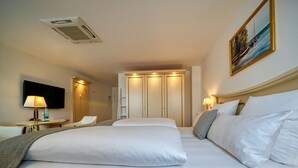 A hotel room with a large bed, a TV, a desk, and a wardrobe. - Hotel Seeblick Wismar (Wismar)