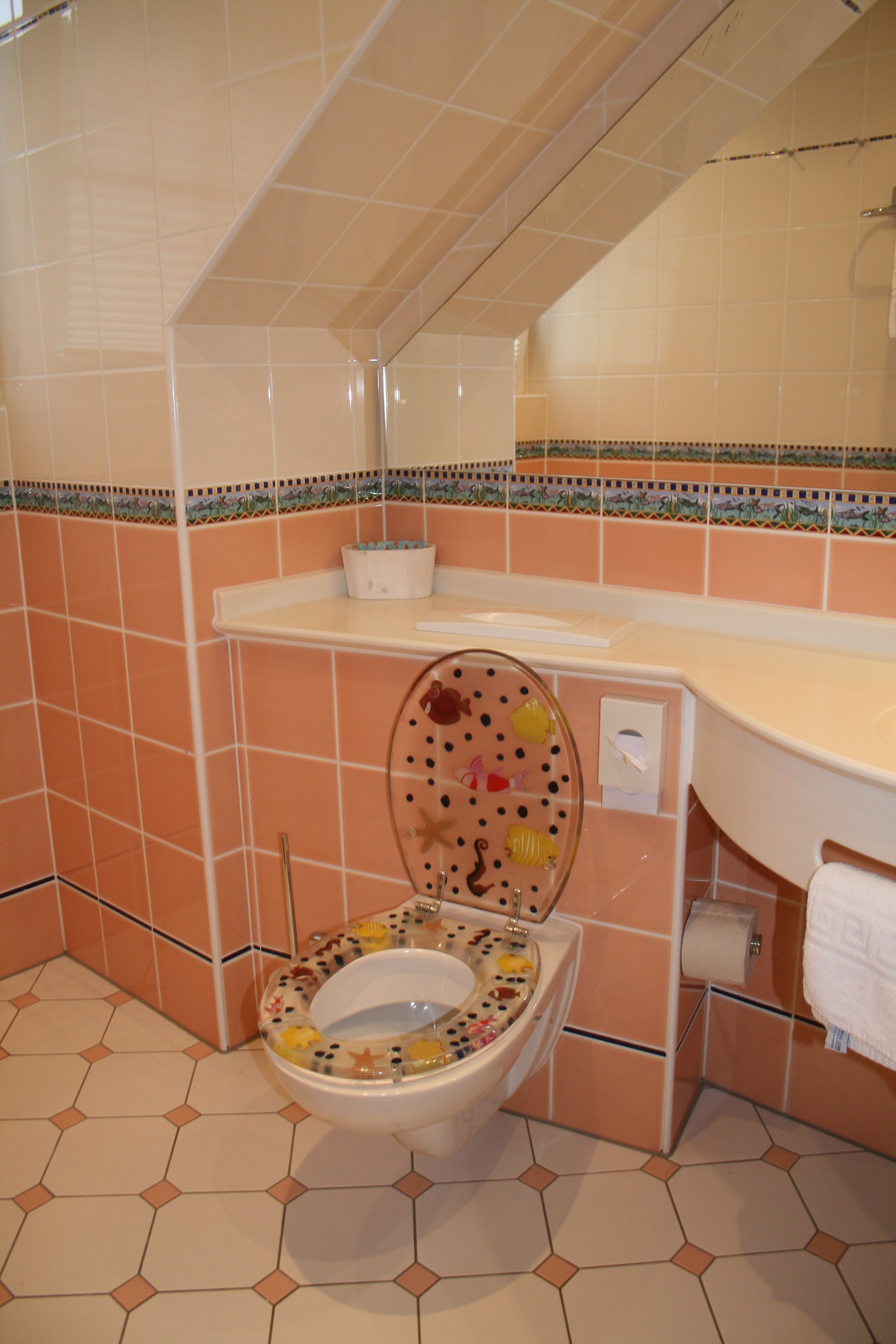 Un baño con inodoro, lavabo y espejo.
