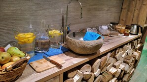 Een landelijke keuken met een stenen spoelbak, houten snijplank en een mand vol fruit.