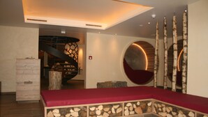 Een modern interieur met een stenen bank, een rond zitgedeelte en een trap.