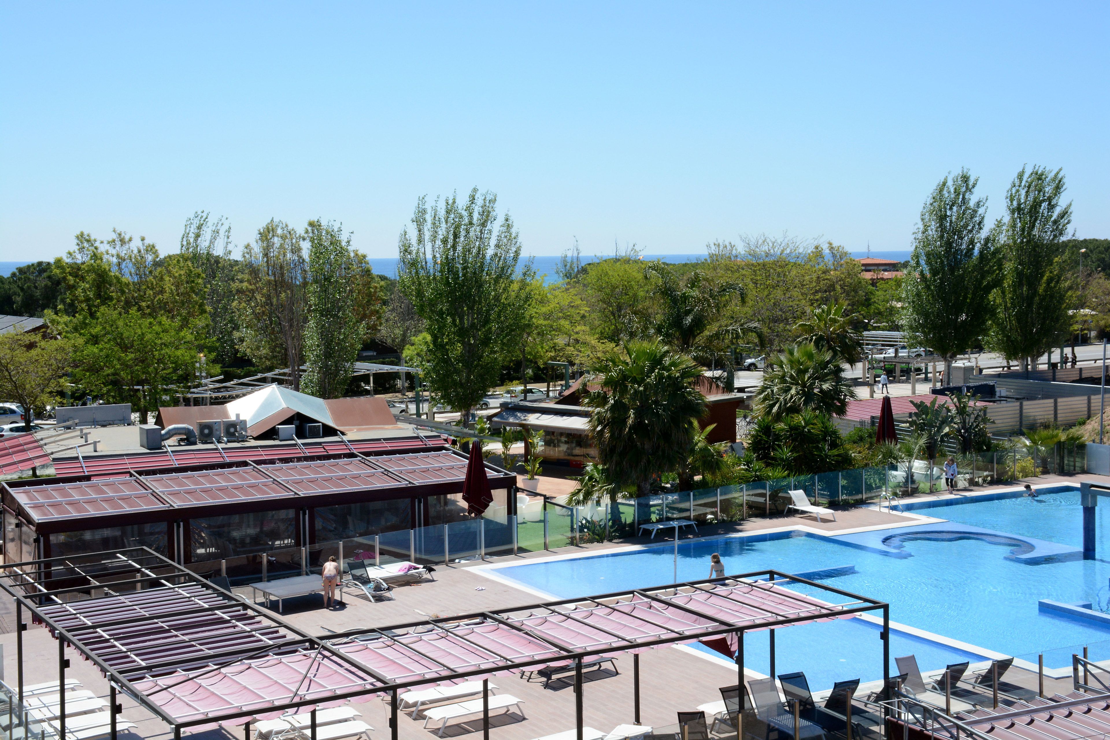 Uma área de piscina no terraço, com espreguiçadeiras, piscina e vista para o oceano.
