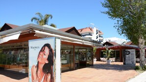 Un hotel con un patio empedrado, un restaurante visible y un cartel con texto.
