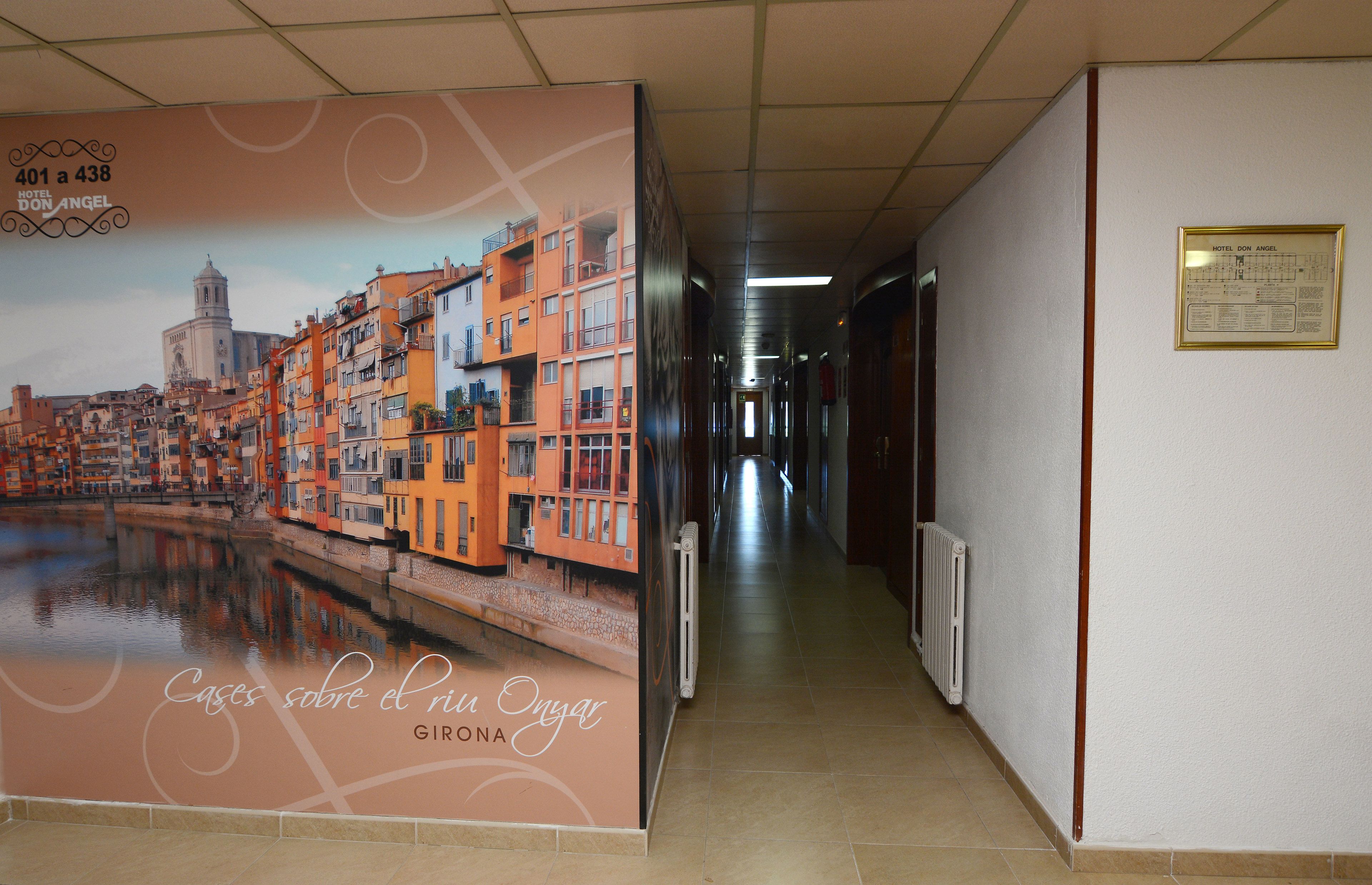 A corridor with a large poster of a cityscape, a plaque on the wall, and a radiator.
