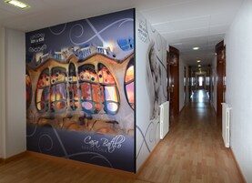 Un pasillo con un gran mural de un edificio y el texto "Casa Batlló Barcelona".