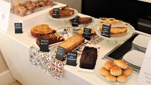 Una vitrina de pastelería con varios pasteles y productos de repostería.