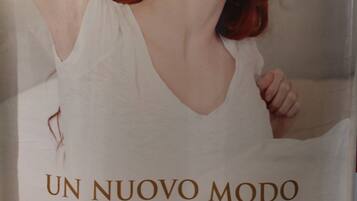 A poster with a person wearing a white top, text in Italian and English, and a website URL.