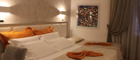 Una habitación de hotel con dos camas, un cuadro abstracto grande en la pared y una ventana con cortinas.