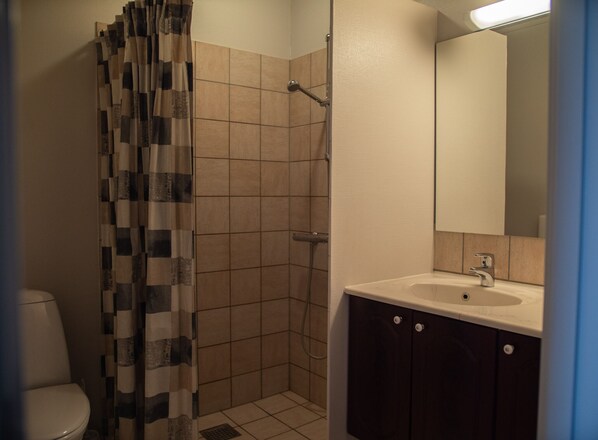 A bathroom with a shower, toilet, and sink.