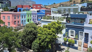 A row of colorful buildings with a mountain in the background.