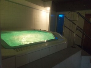 A hot tub in a room with tiled walls and a metal ladder. - Aparthotel Sant Andreu (Arinsal)