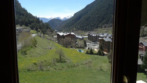 Vista di un villaggio montano con edifici e una piscina.
