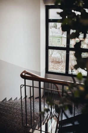 Una escalera con barandilla metálica que lleva a una ventana con varios paneles.