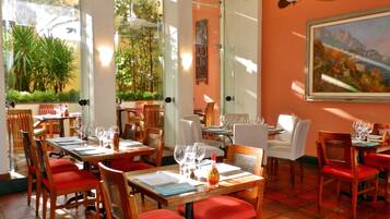 Un restaurante con mesas dispuestas para comer, sillas y un ventilador de techo.