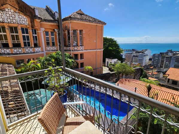 Un balcón con vista a una piscina y al paisaje urbano.