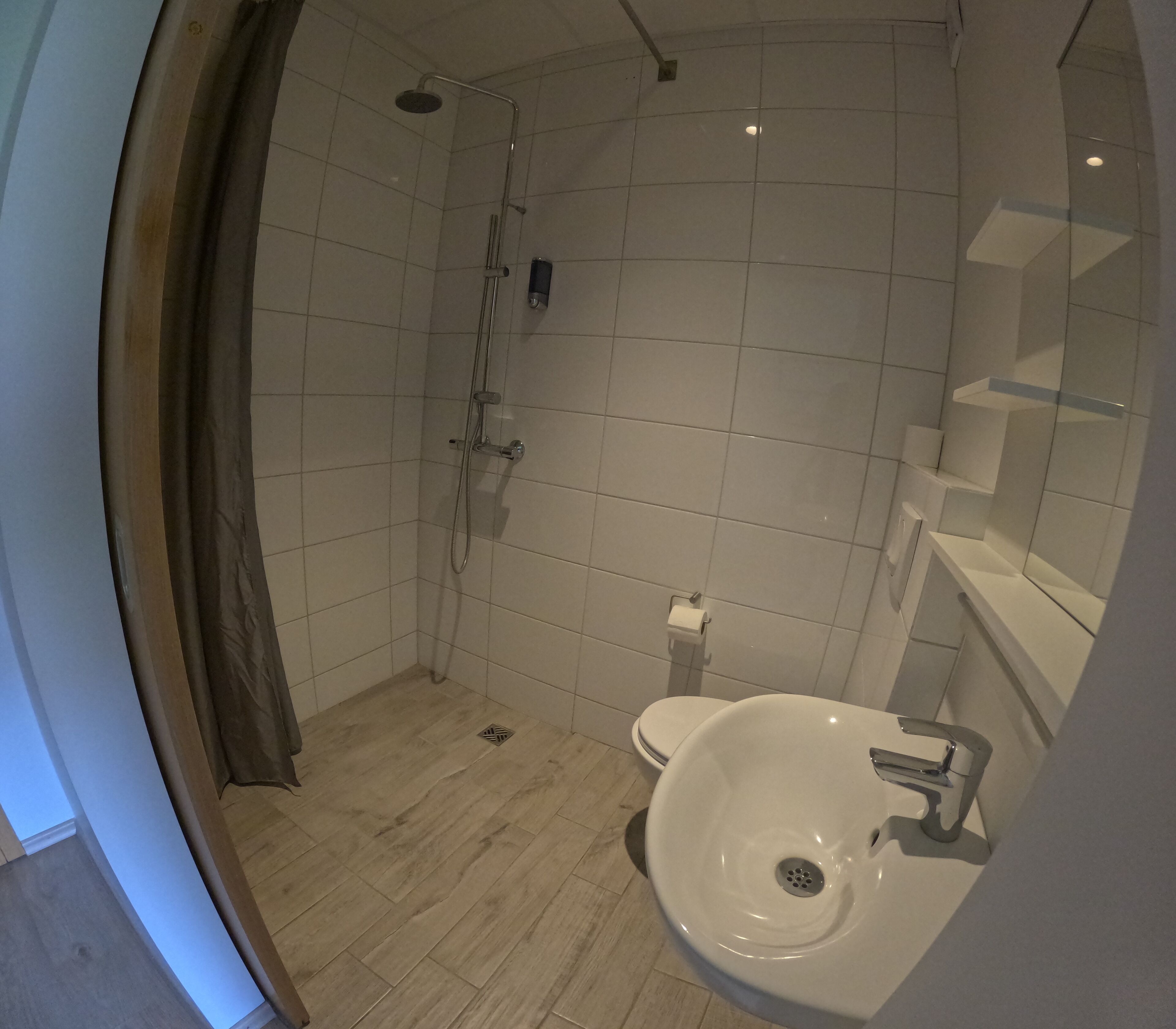 A bathroom with a shower, toilet, and sink.