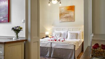 A bedroom with a bed, a nightstand, a lamp, and a painting on the wall.