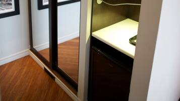Quarto com porta de correr de vidro para vista da cidade, micro-ondas e pequena mesa com tomada.